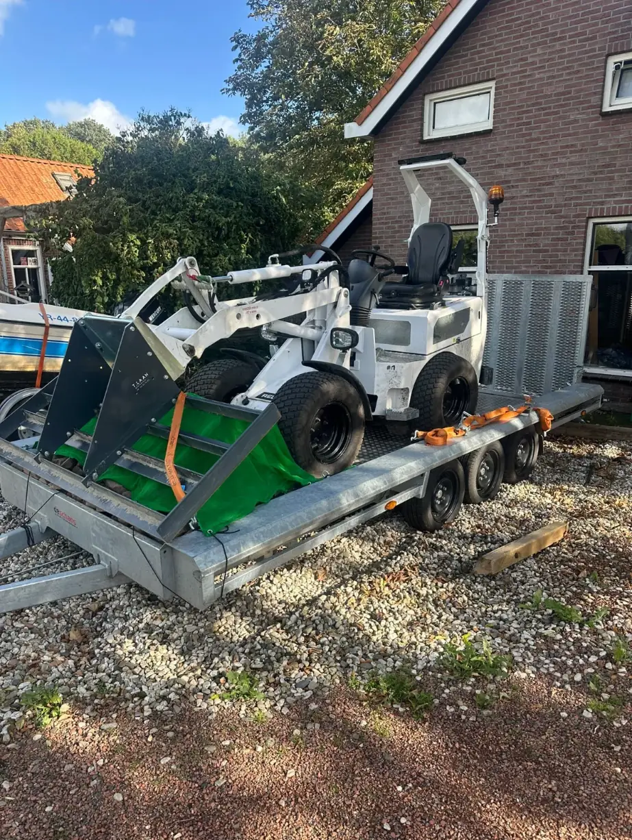 Relly 1.3C minishovel met T.LAAN-bak, vastgezet op de aanhanger
